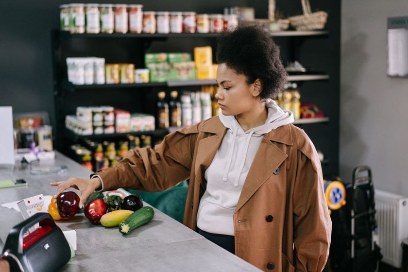 A hand holding a food package and reading the nutrition label